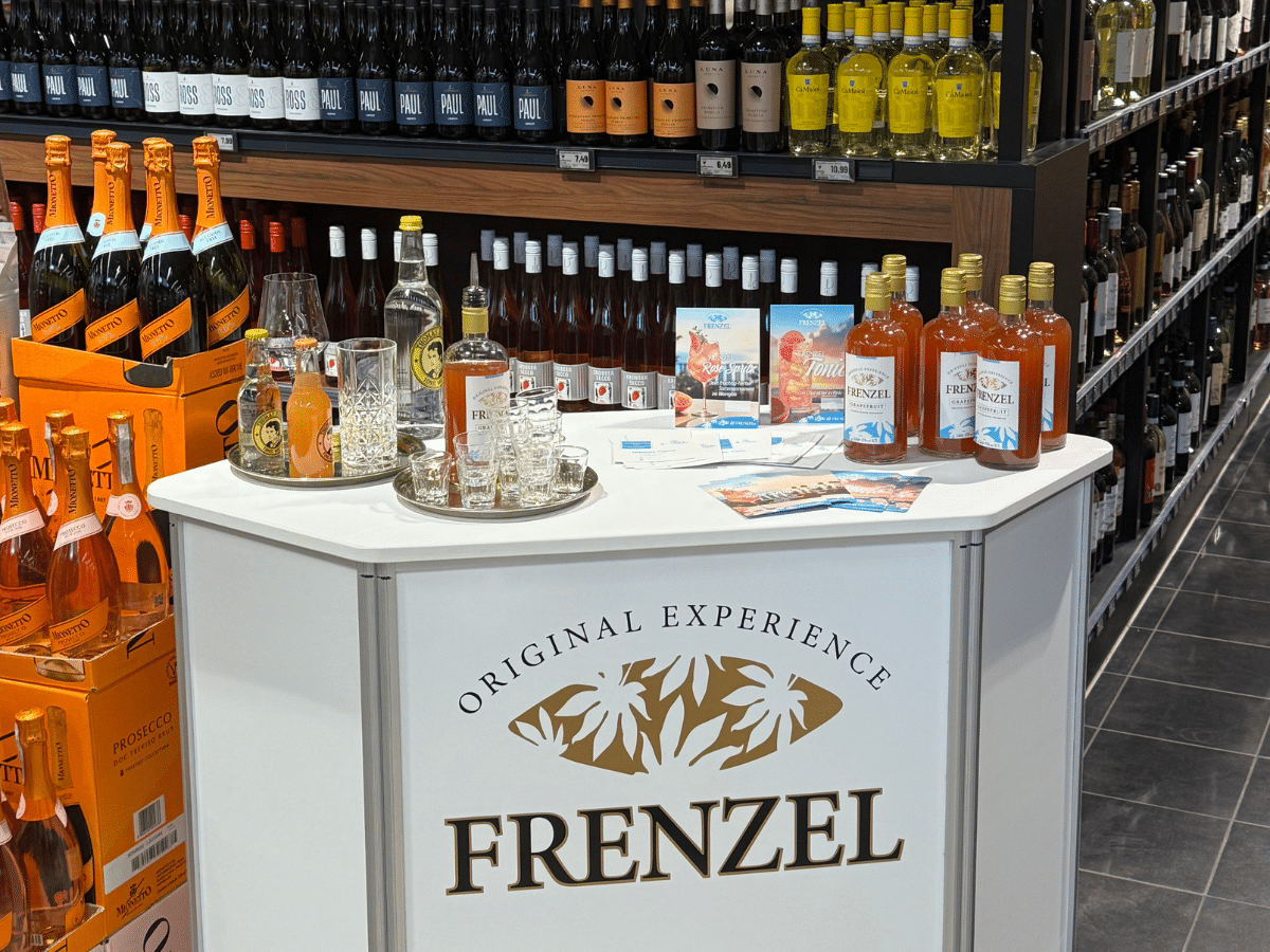 Ein erfrischender Cocktail mit FRENZEL Grapefruit Likör, garniert mit Zitrone, Minze und Eiswürfeln in einem edlen Glas.