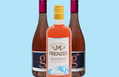 FRENZEL Grapefruit Likör mit zwei Flaschen Secco Rosé vor hellblauem Hintergrund