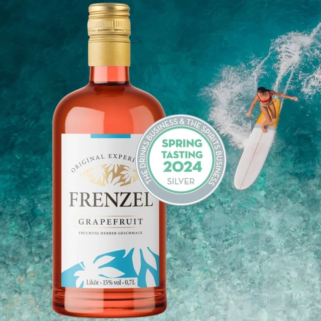 FRENZEL Grapefruit Likör mit Silbermedaille beim Spring Tasting 2024 von The Spirits Business – Flasche vor türkisblauem Meer mit Surferin.